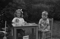 Girl & boy at table in garden_nd_cropped